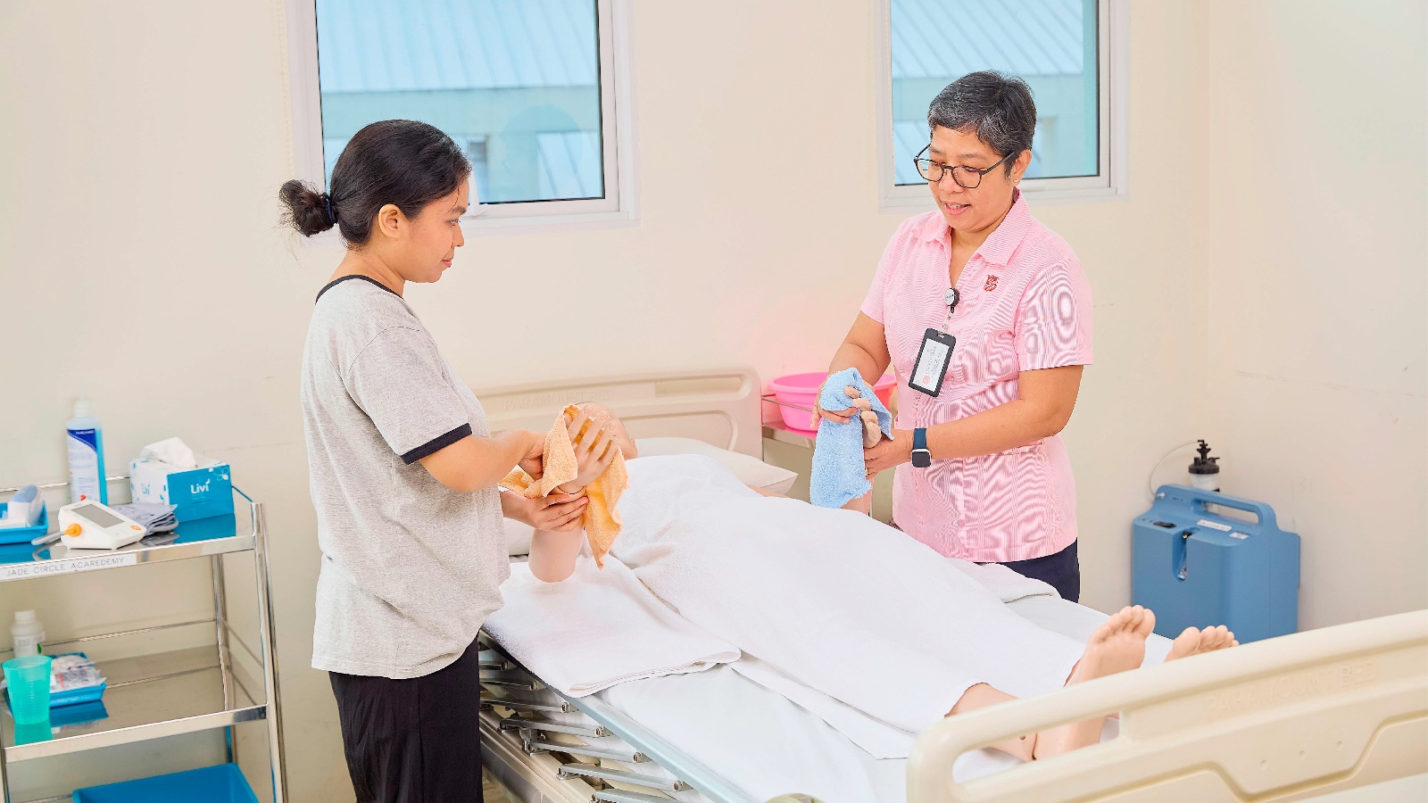 helper learning to clean an elderly person